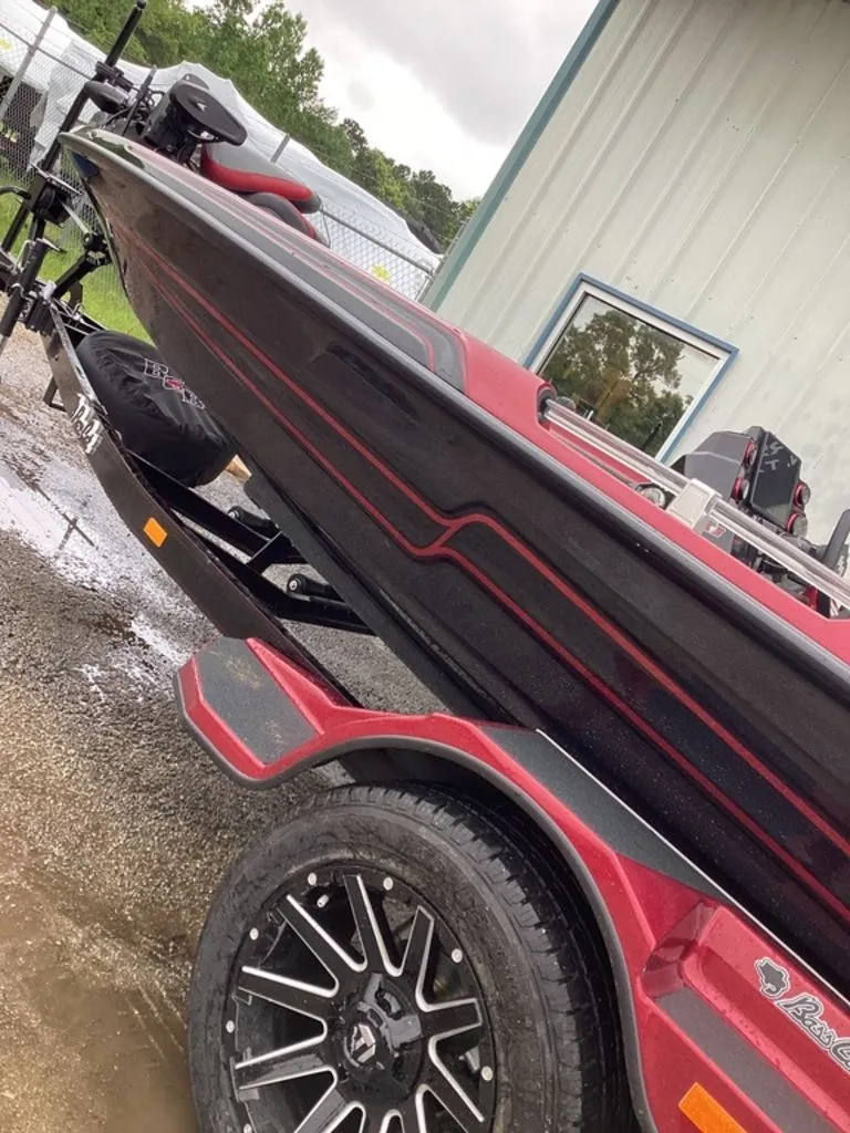 Slide: The Image of 2026 Bass Cat Eyra SP boat on trailer, red and black, side view. - 5