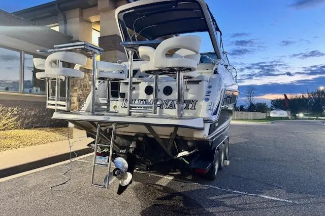 Slide: The Image of 1995 Maxum 2700 SR boat with seating, parked at sunset near a building. - 10