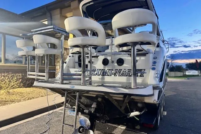 Slide: The Image of 1995 Maxum 2700 SR boat with custom bar stools on the deck at sunset. - 12