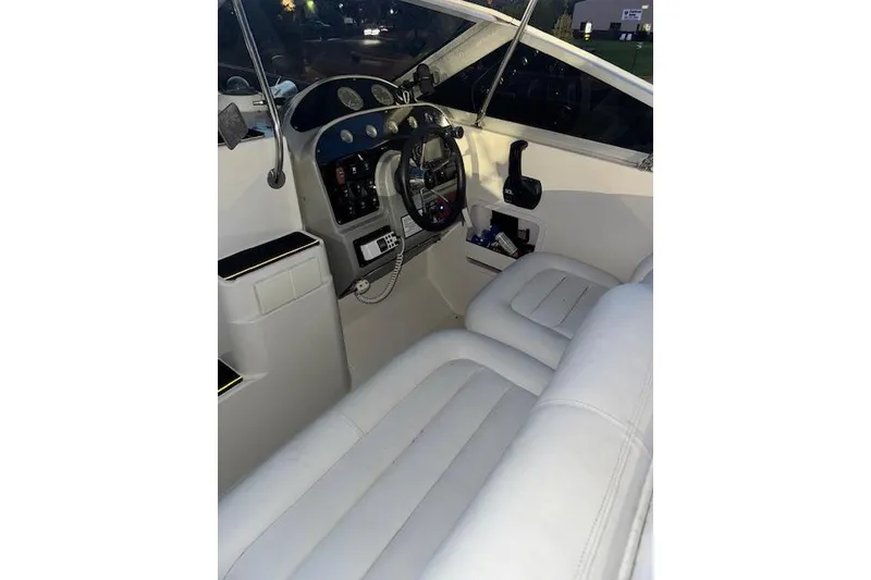 Slide: The Image of Interior view of 1995 Maxum 2700 SR boat cockpit with white seating and control panel. - 18