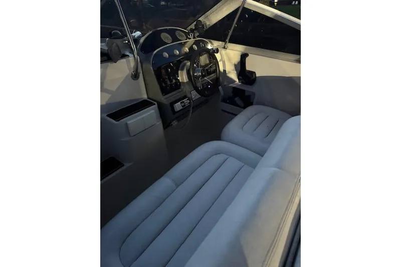 Slide: The Image of Interior of a 1995 Maxum 2700 SR boat, featuring steering wheel and dashboard controls. - 19