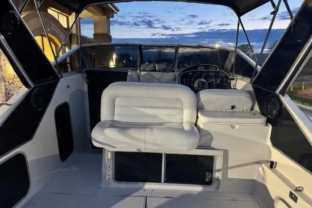 Slide: The Image of 1995 Maxum 2700 SR boat interior with white seating and steering console at sunset. - 21