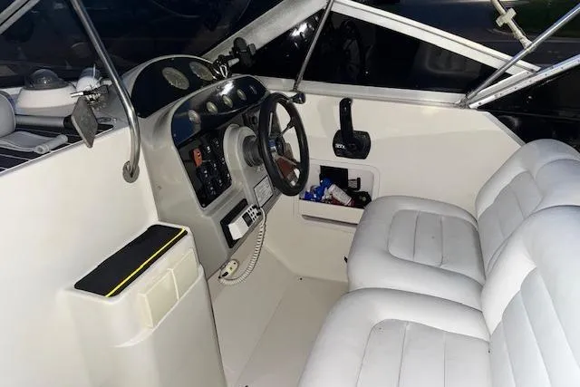 Slide: The Image of Interior of a 1995 Maxum 2700 SR boat with white seating and control panel. - 23