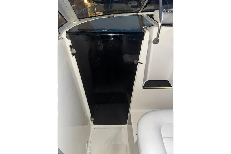 Slide: The Image of 1995 Maxum 2700 SR boat interior with open black storage compartment. - 24