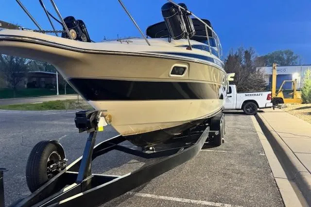 Slide: The Image of 1995 Maxum 2700 SR boat on trailer, parked in a lot, evening setting. - 5