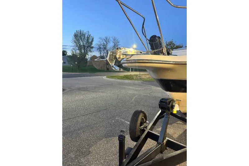 Slide: The Image of 1995 Maxum 2700 SR boat on trailer at dusk, parked on a street. - 8
