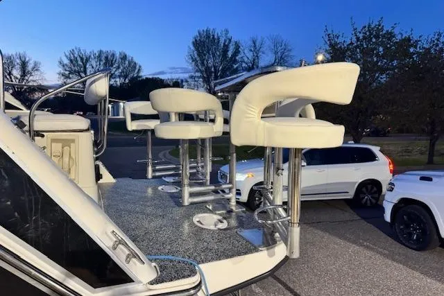 Slide: The Image of 1995 Maxum 2700 SR boat with stylish seating, parked near vehicles at dusk. - 9