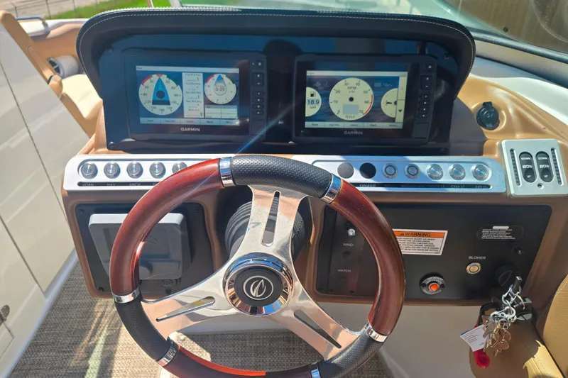 Slide: The Image of 2021 Crownline Eclipse E235 dashboard with Garmin displays and wood-accented steering wheel. - 14