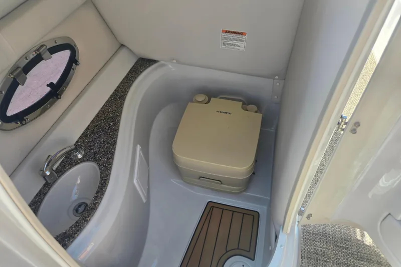 Slide: The Image of 2021 Crownline Eclipse E235 boat bathroom with sink and portable toilet. - 17