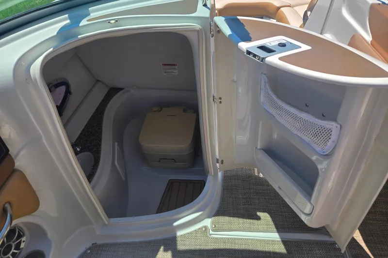 Slide: The Image of 2021 Crownline Eclipse E235 boat interior with compact restroom and storage. - 18