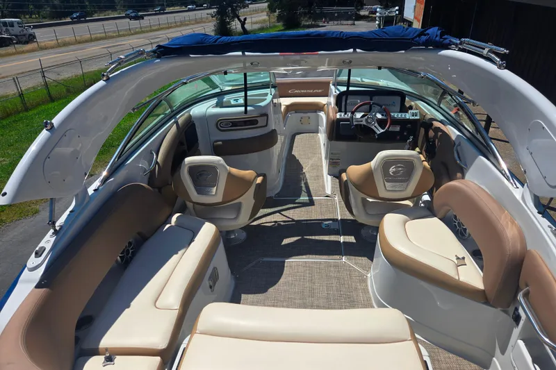 Slide: The Image of 2021 Crownline Eclipse E235 boat interior with beige seating and modern dashboard. - 20