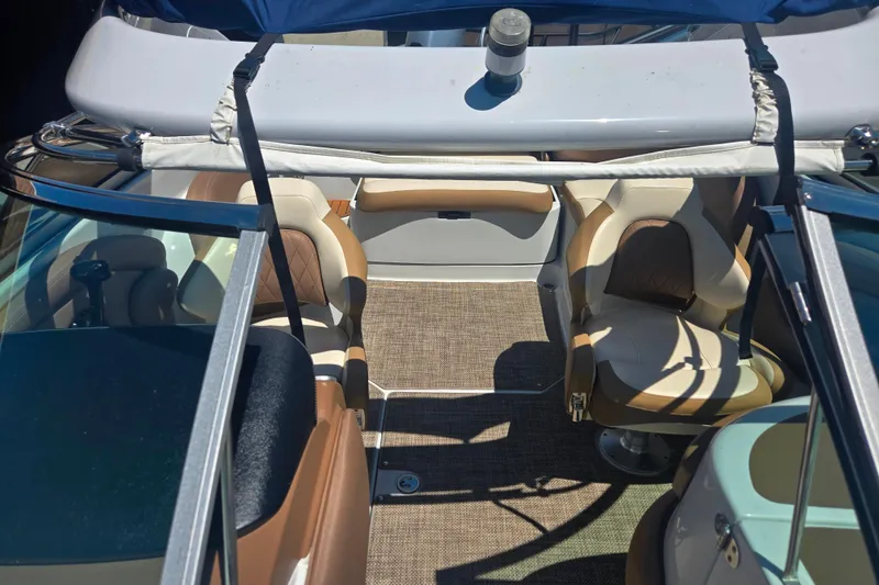 Slide: The Image of 2021 Crownline Eclipse E235 boat interior with tan seating and carpeted floor. - 25
