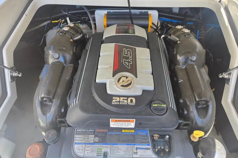 Slide: The Image of Engine compartment of a 2021 Crownline Eclipse E235 boat, featuring a Mercury 4.5L engine. - 26