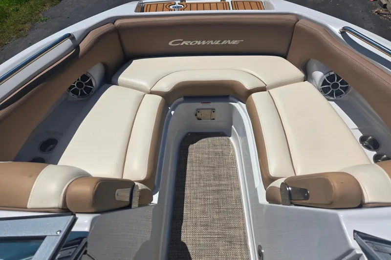 Slide: The Image of 2021 Crownline Eclipse E235 boat interior with beige seating and carpeted floor. - 9