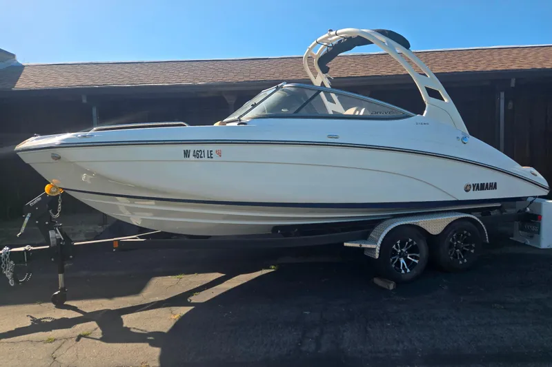 The Image of 2022 Yamaha Boats 212SD on trailer, parked outdoors, side view. - 1