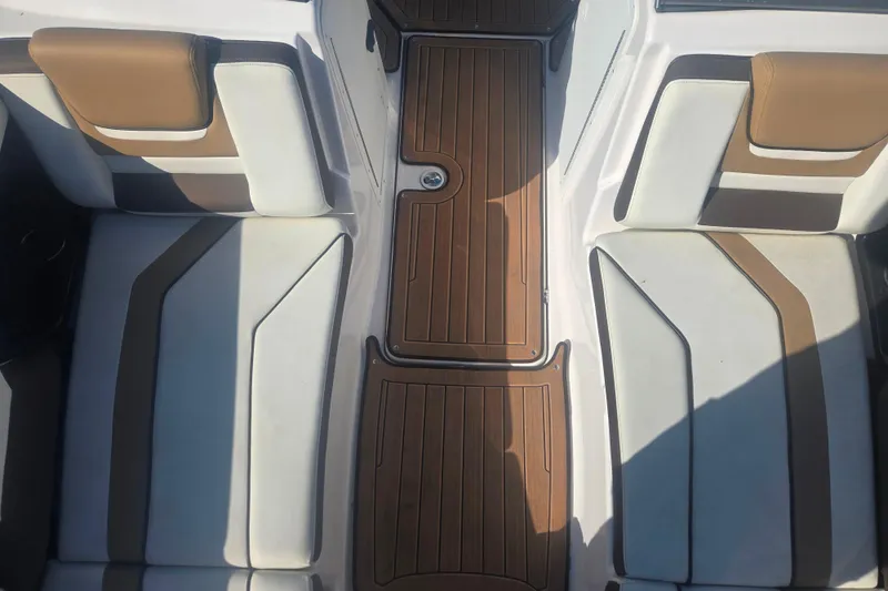 Slide: The Image of 2022 Yamaha Boats 212SD interior with brown and white seating and teak-style flooring. - 10