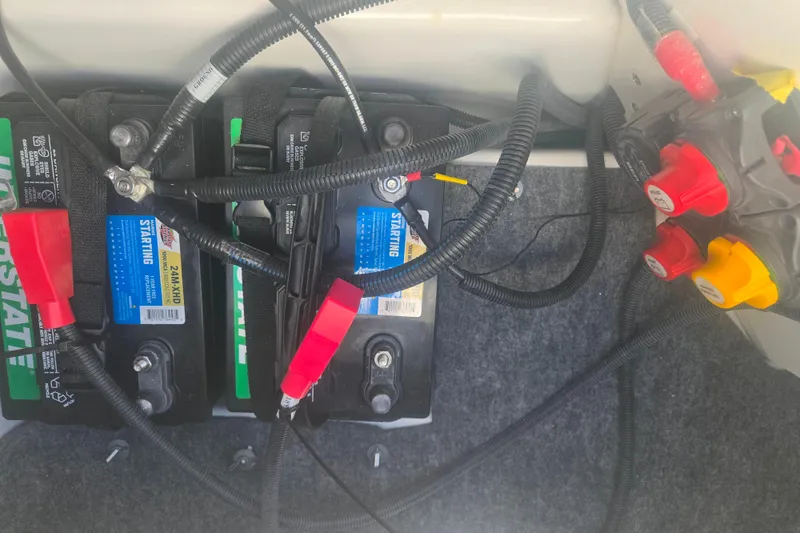 Slide: The Image of Battery compartment of a 2022 Yamaha Boats 212SD, featuring wiring and connections. - 12