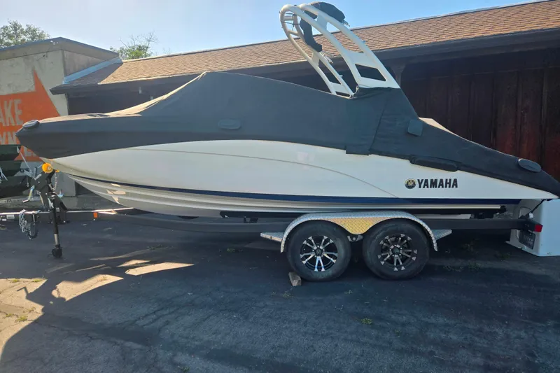 Slide: The Image of 2022 Yamaha Boats 212SD covered on trailer, parked outdoors. - 19