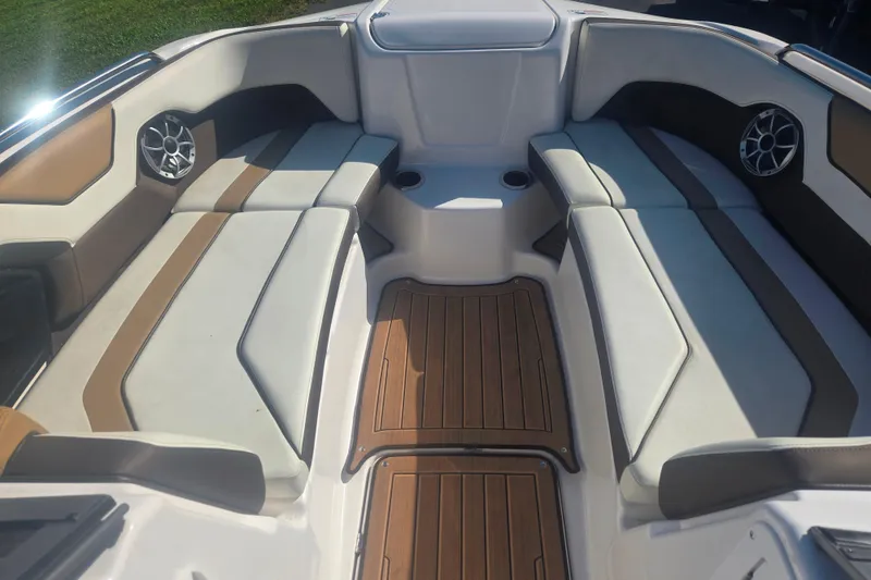 Slide: The Image of 2022 Yamaha Boats 212SD interior with cushioned seating and wood-style flooring. - 7