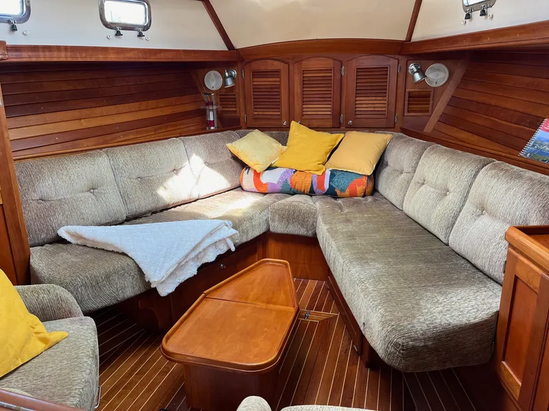 Slide: The Image of Cozy interior of 1996 Gozzard 44 AC sailboat with plush seating and wooden accents. - 13