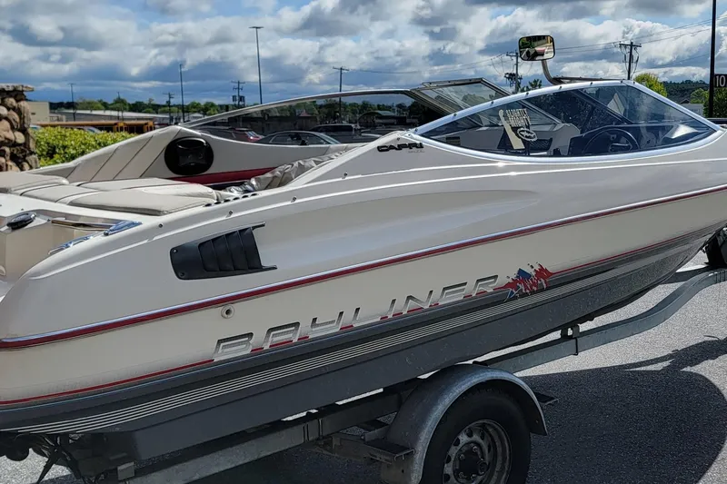 Slide: The Image of 1990 Bayliner 1850 Capri boat on trailer under cloudy sky. - 3