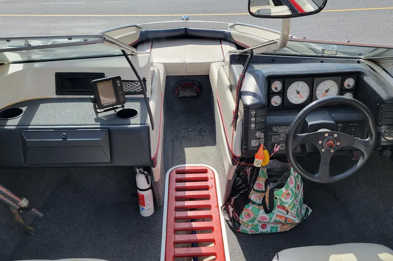 Slide: The Image of 1990 Bayliner 1850 Capri boat interior with steering wheel, gauges, and navigation equipment. - 6