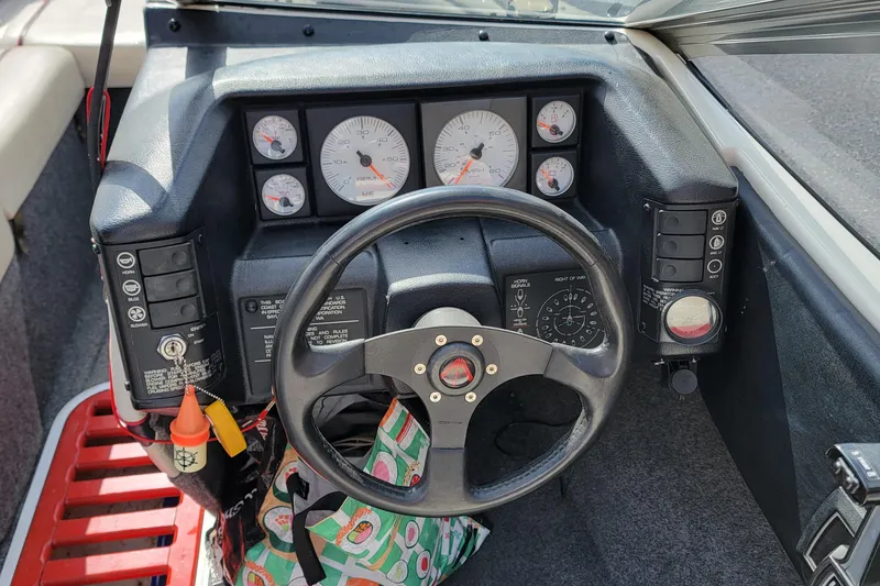 Slide: The Image of Dashboard of a 1990 Bayliner 1850 Capri boat with steering wheel and gauges. - 7