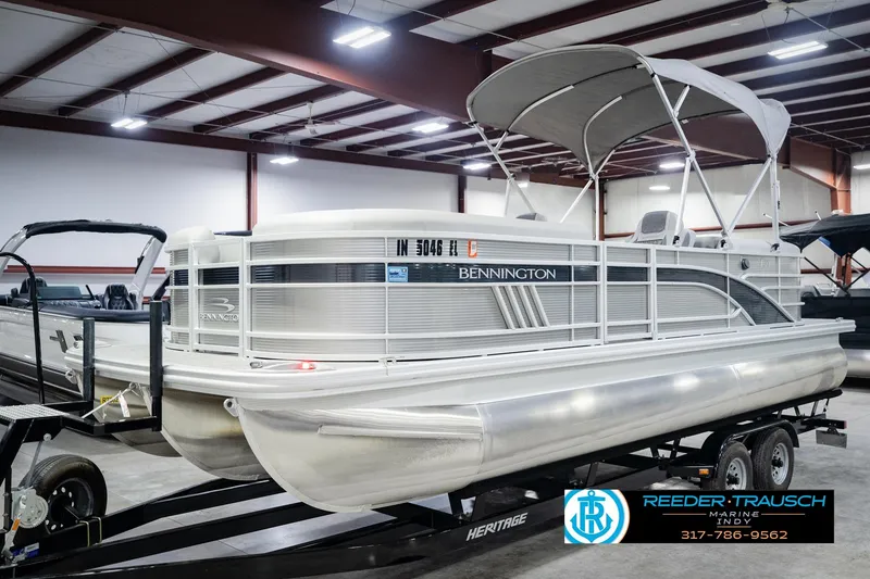 Slide: The Image of 2023 Bennington 23 LSR pontoon boat displayed indoors on a trailer. - 2