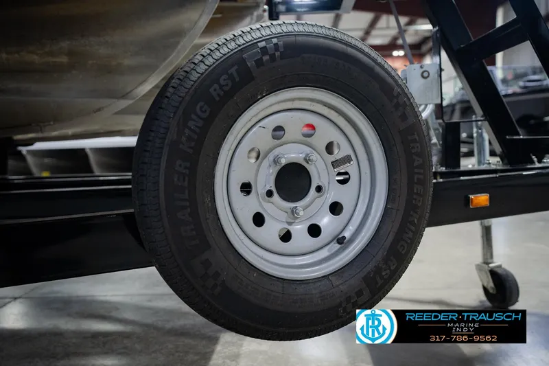 Slide: The Image of Trailer wheel of a 2023 Bennington 23 LSR boat on display indoors. - 64