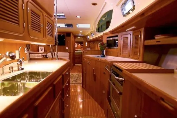 Slide: The Image of Luxurious interior of 2012 Passport Vista 545 Center Cockpit yacht with wooden cabinetry and modern amenities. - 7