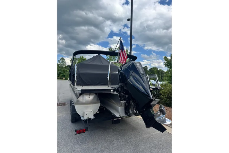 The Image of 2023 Barletta C22U pontoon boat with outboard motor and American flag. - 1