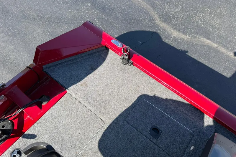 Slide: The Image of 2024 Tracker Pro Team 175 TXW boat interior with red trim and gray carpet. - 16
