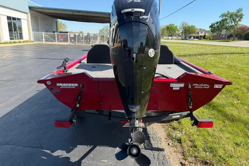 Slide: The Image of 2024 Tracker Pro Team 175 TXW boat, rear view with motor, parked outdoors. - 2