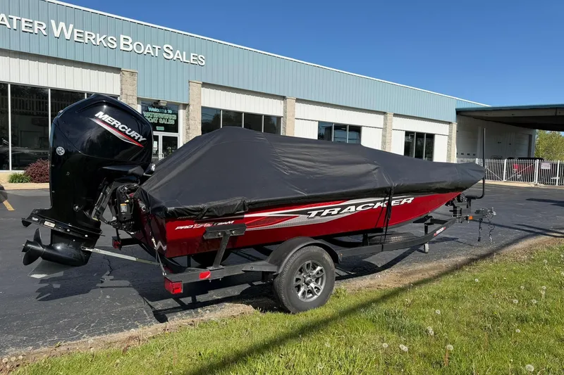 Slide: The Image of 2024 Tracker Pro Team 175 TXW boat with cover at dealership, featuring Mercury outboard motor. - 4