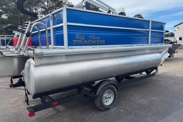 Slide: The Image of 2026 Sun Tracker Party Barge 16 DLX pontoon boat on trailer, blue and silver design. - 5