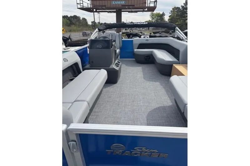 Slide: The Image of 2026 Sun Tracker Party Barge 16 DLX interior with gray seating and blue accents. - 7