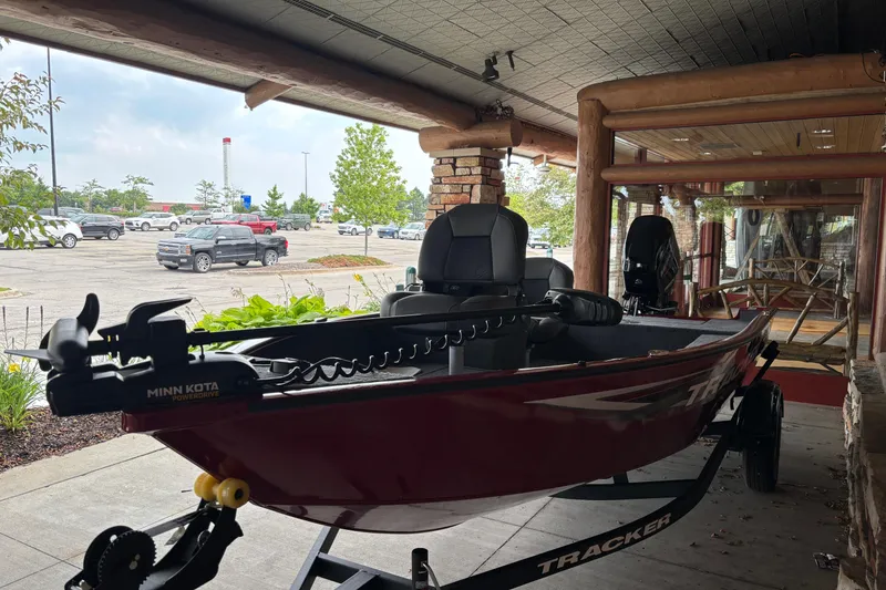 Slide: The Image of 2026 Tracker Super Guide V-16 SC boat displayed indoors with Minn Kota motor. - 4