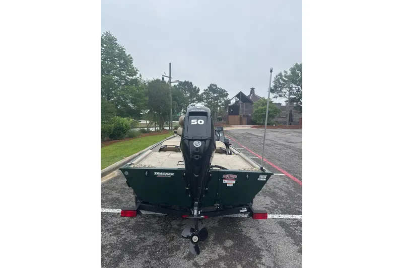 Slide: The Image of 2026 Tracker Bass Tracker Classic Limited boat with 50 HP motor in parking lot. - 3