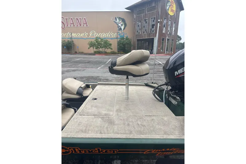 Slide: The Image of 2026 Tracker Bass Tracker Classic Limited boat with seating, parked near Bass Pro Shops. - 6