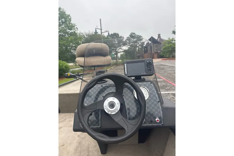 Slide: The Image of 2026 Tracker Bass Tracker Classic Limited boat dashboard with steering wheel and navigation system. - 9