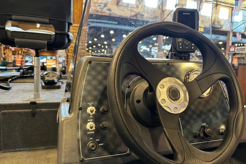 Slide: The Image of 2026 Tracker Bass Tracker Classic XL boat dashboard with steering wheel and controls. - 12