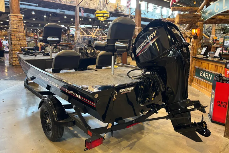 Slide: The Image of 2026 Tracker Bass Tracker Classic XL boat with Mercury engine displayed indoors. - 15