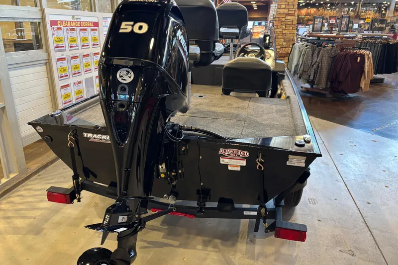 Slide: The Image of 2026 Tracker Bass Tracker Classic XL boat displayed indoors with a powerful Mercury engine. - 16