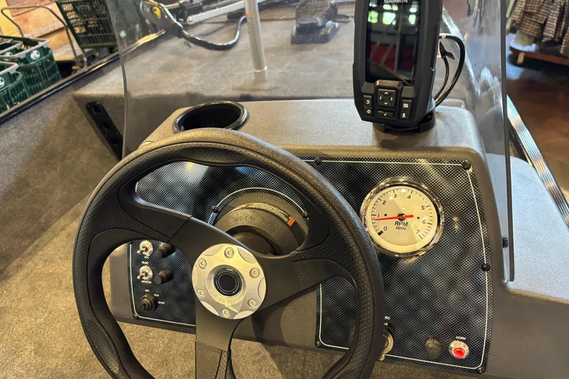 Slide: The Image of Steering console of 2026 Tracker Bass Tracker Classic XL with RPM gauge and Garmin device. - 2