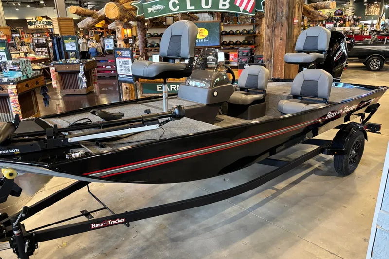 Slide: The Image of 2026 Tracker Bass Tracker Classic XL boat displayed in a showroom with fishing gear. - 4