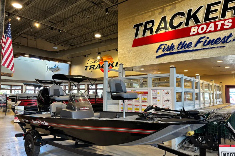 Slide: The Image of 2026 Tracker Bass Tracker Classic XL boat displayed in showroom with promotional signage. - 5