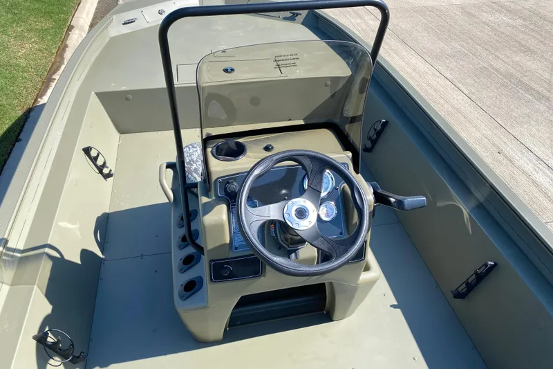 Slide: The Image of 2026 Tracker Grizzly 1860 CC boat interior with steering console and controls. - 10