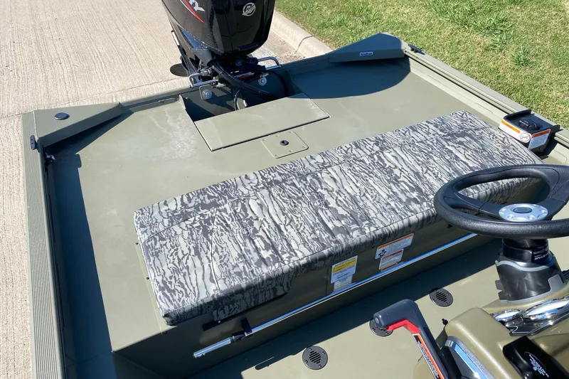 Slide: The Image of 2026 Tracker Grizzly 1860 CC boat interior with camouflage seating and steering wheel. - 11