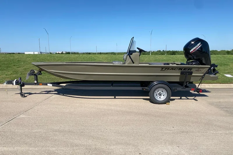 Slide: The Image of 2026 Tracker Grizzly 1860 CC boat on trailer, parked on concrete with grassy background. - 3