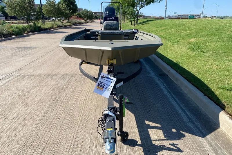 Slide: The Image of 2026 Tracker Grizzly 1860 CC boat on trailer, parked on a sunny road. - 5